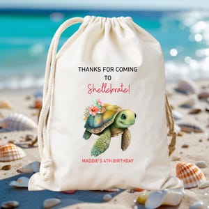 May include: A cream-colored drawstring bag with a sea turtle illustration and the text "THANKS FOR COMING TO Shellebrate!" and "MADDIE'S 4TH BIRTHDAY". The turtle has a yellow and green shell with floral accents.