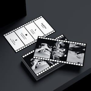 Puede incluir: Tarjetas de visita con dise&ntilde;o de tira de pel&iacute;cula. Las tarjetas son en blanco y negro, con el nombre "Jacob Eva, Director" impreso. Tambi&eacute;n se incluye informaci&oacute;n de contacto. Se ve una pila de tarjetas.