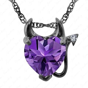 May include: A silver-toned necklace with a pendant featuring a purple heart-shaped gemstone. The pendant is designed with devil horns and a tail, with a small diamond accent on the tail.
