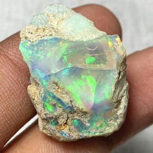 Könnte beinhalten: Weißer Keramikbecher mit schwarzem Henkel und dem Text "But First, Coffee" in schwarzer Schrift. Der Becher steht vor einem verschwommenen Hintergrund, der eine gemütliche Atmosphäre andeutet.