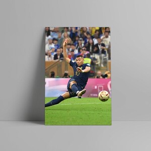 May include: A framed print of a soccer player in a navy blue uniform kicking a soccer ball on a green field. The player is wearing the number 10. The background shows a crowd of people.