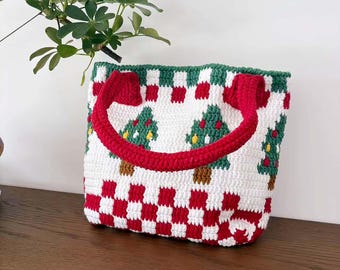 May include: A handmade crochet tote bag featuring a Christmas tree pattern. The bag has a white base with red and green accents, including a checkered pattern and red handles. The Christmas trees are green with brown trunks.
