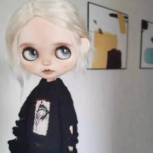 Close-up of embroidered monster face on black knit sweater for dolls