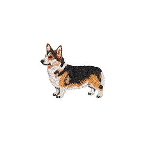 May include: An embroidered patch featuring a tricolour Pembroke Welsh Corgi dog standing in profile. The dog has black, tan, and white fur, pointed ears, and a short tail. The embroidery uses detailed thread work to define the coat texture.