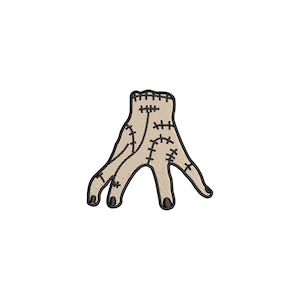Può includere: Toppa ricamata raffigurante una mano beige con cuciture nere e unghie nere. La mano ha un design stilizzato unico con cuciture visibili, che le conferiscono un aspetto strutturato. Perfetto per aggiungere un tocco spettrale a vestiti o accessori.