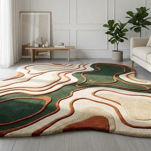 May include: A modern area rug with an abstract design. The rug features a layered pattern with shades of green, beige, and rust-orange. The rug is placed in a living room setting with a sofa and plants.