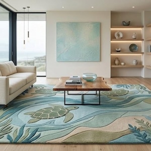 May include: A living room featuring a beige sofa, a wooden coffee table, and a large area rug with a sea turtle design. The rug has shades of blue, green, and beige. A large painting and built-in shelves with decor complete the room.