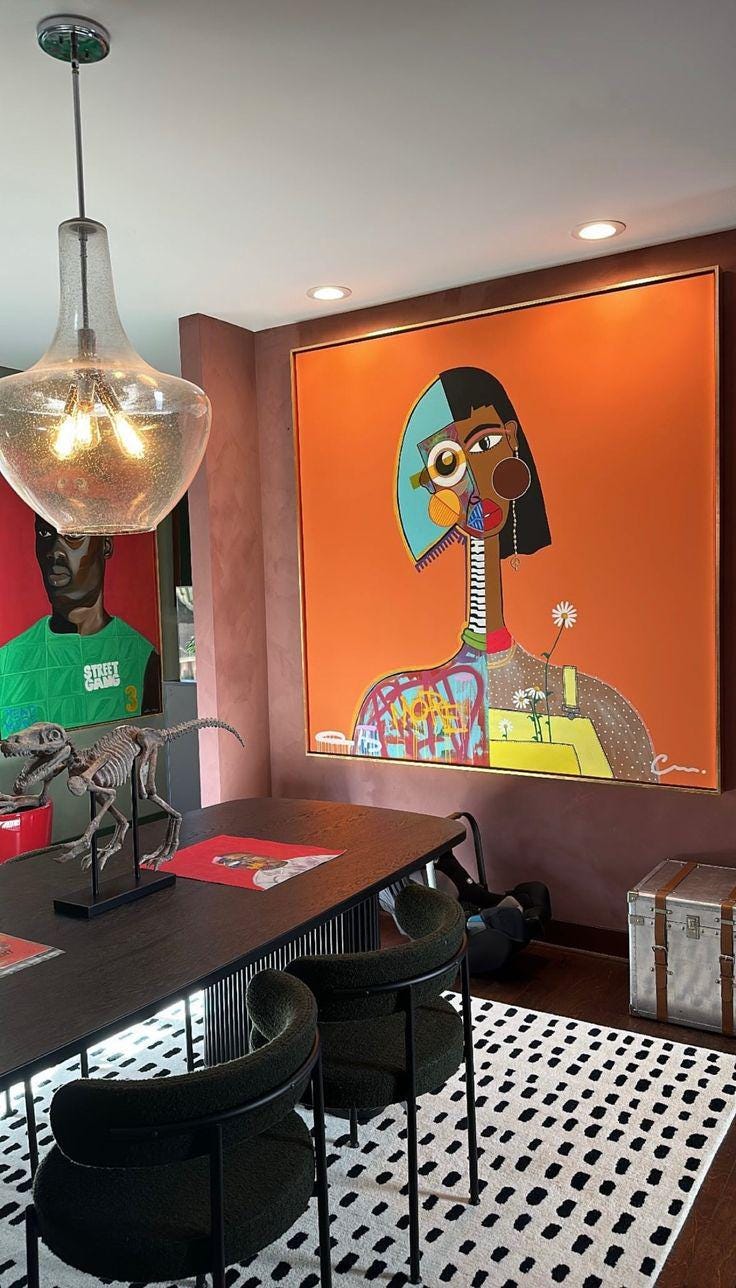 The image shows a modern dining room with two striking pieces of artwork