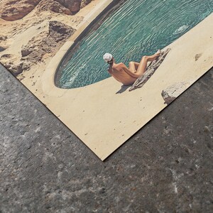 A person is sitting on a rock near a pool, enjoying the serene beach setting.