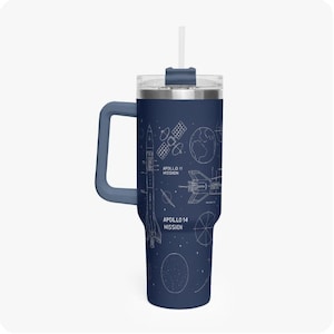 May include: Navy blue travel mug with a white schematic design of the Apollo 11 and 14 missions. The mug has a handle, a clear lid, and a white straw. The mug is approximately 10 inches tall.