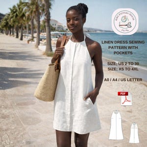 Puede incluir: Una mujer con un vestido halter de lino blanco con bolsillos, sosteniendo un bolso de mano de paja. La imagen incluye texto que indica un patrón de costura de vestido de lino disponible en tallas US 2 a 30 y XS a 4XL. El fondo muestra una playa.