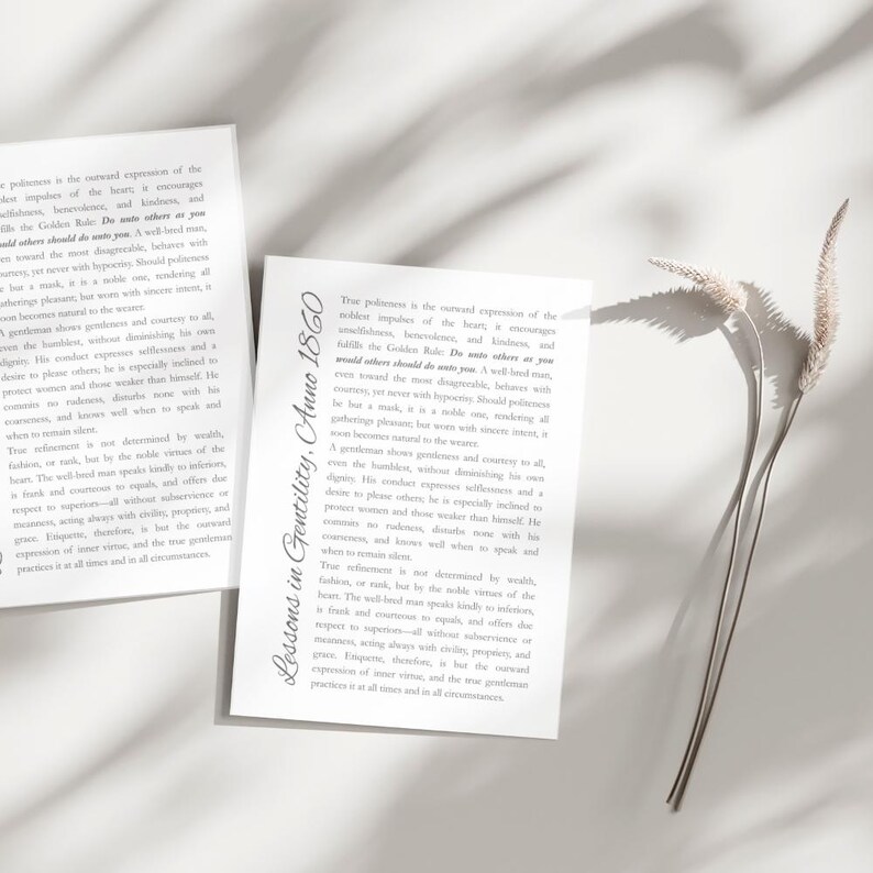 May include: Two white rectangular cards with black text, one slightly angled, displaying text about gentility. The text includes the phrase "Lessons in Gentility, Anno 1860." A sprig of dried grass casts a shadow.