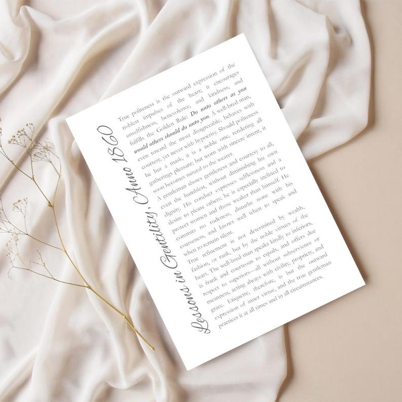 May include: A white card with the text "Lessons in Gentility, Anno 1860" and a passage about politeness, kindness, and the Golden Rule. The card is on a cream-colored fabric with a sprig of dried flowers.