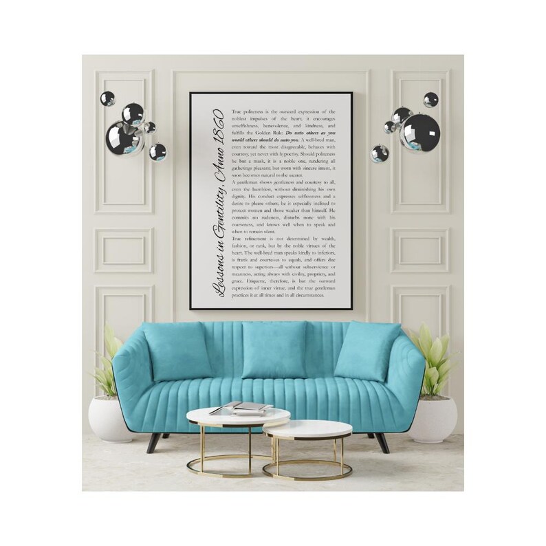 May include: A modern living room setup featuring a teal blue sofa with three matching throw pillows. Two white and gold accent tables sit in front of the sofa. A framed print with text hangs above the sofa, and decorative silver spheres adorn the wall.