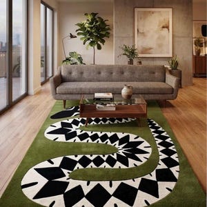 Könnte beinhalten: Ein rechteckiger Teppich mit einem großen, geschlängelten Schlangenmotiv in Schwarz und Weiß auf einem einfarbigen olivgrünen Hintergrund. Das Schlangendesign besteht aus sich wiederholenden Rautenformen und segmentierten Mustern.