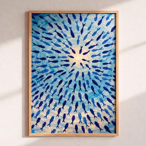 Peut inclure: Une œuvre d'art encadrée représentant un banc de poissons bleus nageant en cercle vers une source de lumière centrale. La peinture présente des coups de pinceau visibles, donnant une texture. Le cadre est en bois clair.