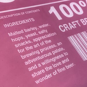 Puede incluir: Una etiqueta rosa con texto blanco que describe los ingredientes de una cerveza artesanal. El texto dice "DESCRIPTION OF CONTENTS INGREDIENTS Malted barley, water, hops, yeast, salty snacks, appreciation for the art of the brewing process, an adventurous palate, and a willingness to share the love and wonder of fine beer." La etiqueta tambi&eacute;n incluye el texto "100% CRAFT BEER".