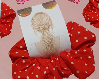 Puede incluir: Tres coleteros de tela roja con lunares blancos. Una tarjeta de presentación central muestra la ilustración de una persona con cabello rubio recogido en una coleta con un coletero a juego, con el texto The Chalky Fox y Spotty Scrunchies.
