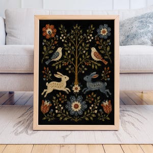 Op de afbeelding: Een ingelijste kunstdruk met een zwarte achtergrond, met een boom, vogels en konijnen. Het ontwerp bevat bloemelementen in rood, blauw en crème. De lijst is gemaakt van lichtgekleurd hout, wat een natuurlijke uitstraling geeft.
