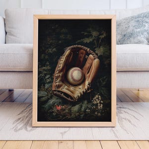 Peut inclure: Impression d'art encadrée d'un gant et d'une balle de baseball au milieu de la verdure. Le gant est en cuir bronzé et la balle a des coutures rouges. L'œuvre d'art a un aspect vintage, avec l'accent mis sur les textures et les détails des objets.