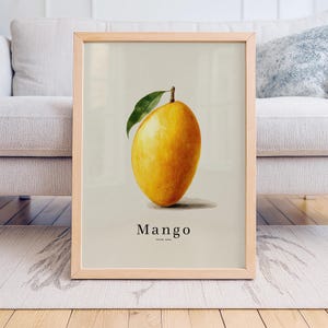 May include: A framed print featuring a ripe mango with a green leaf. The mango is a vibrant yellow color and is labeled "Mango" with the location "Jaipur, India" below the word. The frame is made of light-colored wood.
