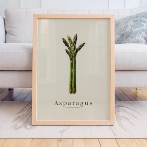 May include: A framed print featuring a botanical illustration of asparagus. The artwork showcases a bundle of green asparagus spears against a light beige background. The word "Asparagus" is printed in a simple font below the image.