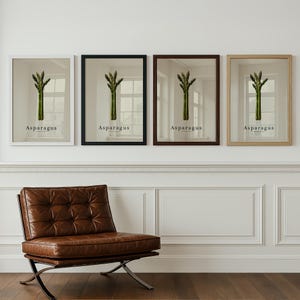 May include: Four framed art prints featuring asparagus illustrations. Each print has a different frame color: white, black, brown, and natural wood. The word "Asparagus" is printed in a simple font below the image of the vegetable.
