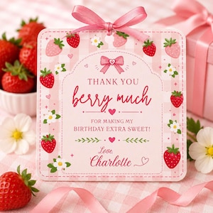 May include: A pink gift tag with a strawberry and floral design. The tag reads "THANK YOU berry much FOR MAKING MY BIRTHDAY EXTRA SWEET! Love, Charlotte". A pink ribbon is attached to the tag, and fresh strawberries are in the background.