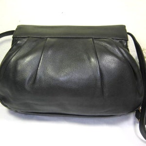 May include: A black leather handbag with a pleated design and a long strap.