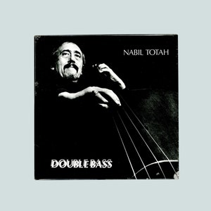 May include: Black and white album cover featuring a man playing a double bass. The album title is "DOUBLE BASS" and the artist's name is "NABIL TOTAH".