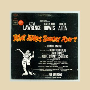 May include: A black and white vintage record album cover featuring a black and white illustration of a couple dancing. The album title is "What Makes Sammy Run?" with the names Steve Lawrence, Sally Ann Howes, and Robert Alda in white text. The album is by Joseph Cates.