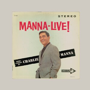 May include: A vintage vinyl record cover featuring a black and white photo of Charlie Manna, a comedian. The cover is white with red text that reads "Manna-Live!" and "More Comedy By Charlie Manna". The record label is Decca.