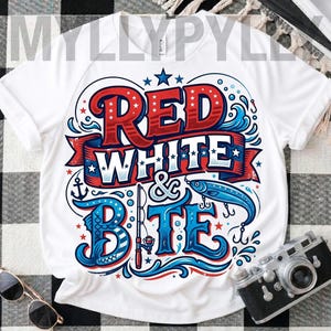 以下が含まれることがあります： 赤と青で「RED WHITE & BITE」の文字が描かれた愛国的なデザインの白いTシャツ。星、波、釣りテーマのイラストが特徴です。アンカー、釣り竿、魚が含まれています。