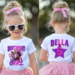 May include: A young girl wearing a white t-shirt with the words "BIRTHDAY GIRL" in purple and glittery text. The shirt features a graphic of three girls. She wears a pink tutu and heart-shaped sunglasses.