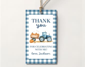 Op de afbeelding: Een rechthoekig cadeaulabel met een blauw-witte ruitjesrand. In het midden staat een blauwe tractor die een houten kar vol oranje pompoenen trekt. De tekst luidt: THANK YOU FOR CELEBRATING WITH ME! love, Jackson in een blauw lettertype.