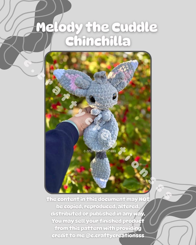 Pu&ograve; includere: Un peluche di cincill&agrave; all'uncinetto nei toni del grigio, blu e rosa. Il giocattolo ha grandi orecchie, un corpo soffice e una piccola coda. Il testo "Melody the Cuddle Chinchilla" &egrave; nella parte superiore dell'immagine.