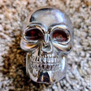Manopla de câmbio vintage cromada em formato de caveira com olhos vermelhos iluminados, estilo hot rod, rat rod, gótico, steampunk, acessório personalizado para carros.