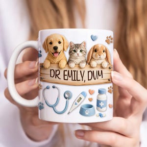 以下が含まれることがあります： ゴールデンレトリバーの子犬、灰色の縞模様の子猫、ウサギが描かれた白いセラミックマグ。マグには「DR. EMILY, DVM」と書かれた木の看板があります。聴診器、体温計、ペットボウルも含まれています。