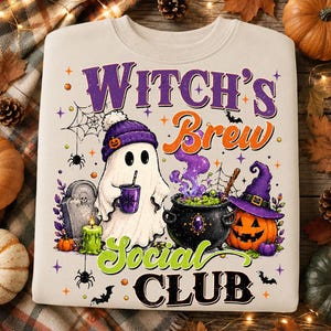 Może przedstawiać: Beżowa bluza z nadrukiem graficznym z napisem "WITCH'S BREW SOCIAL CLUB". Wzór przedstawia ducha w fioletowej czapce trzymającego kubek, czarny kociołek z zieloną cieczą, dynię, nagrobek oraz pająki.
