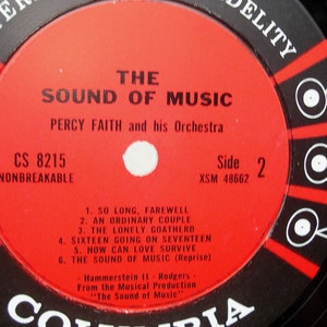 May include: A vintage vinyl record for "The Sound of Music" by Percy Faith and his Orchestra. The red label features black and white text, including song titles and "Side 2." The record is labelled "Nonbreakable."