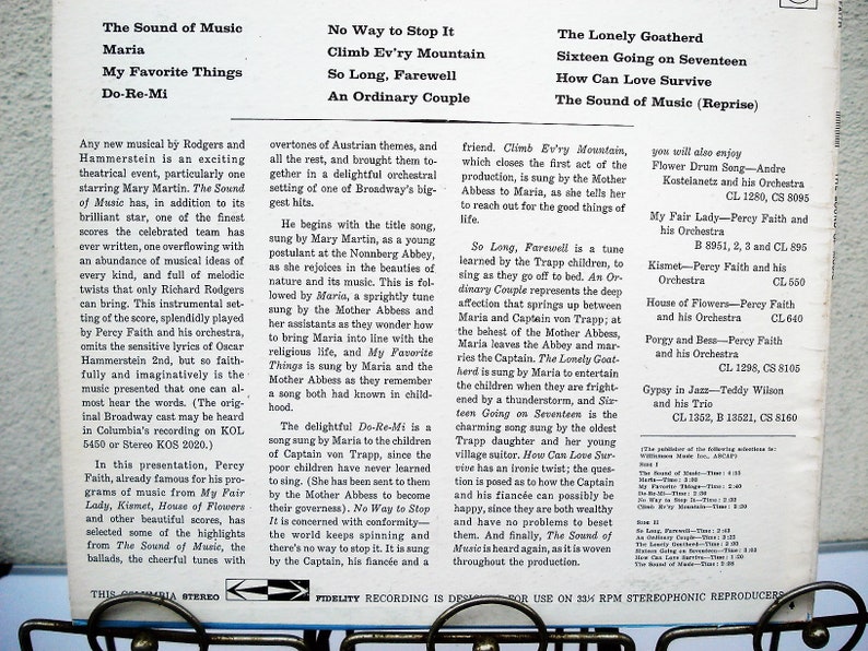 May include: A vintage vinyl record album cover for "The Sound of Music" musical, with song titles and artist information. The cover is white with black text, displaying the album's tracklist and details.