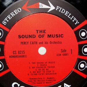 May include: Close-up of a vintage vinyl record label for "The Sound of Music" by Percy Faith and his Orchestra. The label is red with black and white text, including song titles and "Stereo Fidelity".