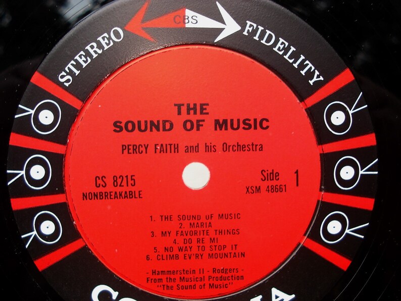 May include: Close-up of a vintage vinyl record label for "The Sound of Music" by Percy Faith and his Orchestra. The label is red with black and white text, including song titles and "Stereo Fidelity".