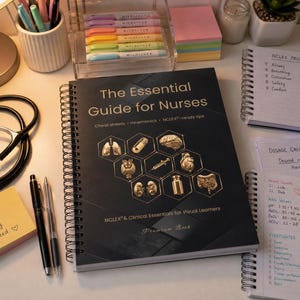 May include: A spiral-bound book titled "The Essential Guide for Nurses" with gold accents and medical illustrations. A stethoscope, pens, and notepads are arranged around the book, along with highlighters and a desk lamp.