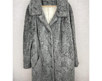 Peut inclure: Un long manteau gris doté d'un extérieur en fausse fourrure bouclée texturée, d'un large col et d'une fermeture à boutons sur le devant. L'intérieur est doublé d'un tissu lisse de couleur claire, le tout sur un cintre en bois.