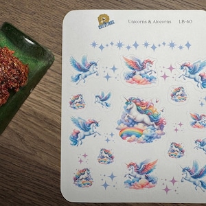 May include: A sheet of stickers featuring various unicorn and alocorn designs. The stickers showcase unicorns with colorful manes and wings, set against clouds and rainbows. The text "Unicorns & Alocorns" is visible.