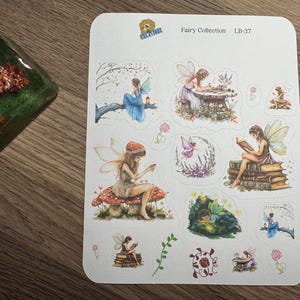 May include: A sheet of fairy-themed stickers. The stickers feature illustrations of fairies in various poses, including reading, writing, and sitting on mushrooms. The stickers are colorful with a whimsical design.