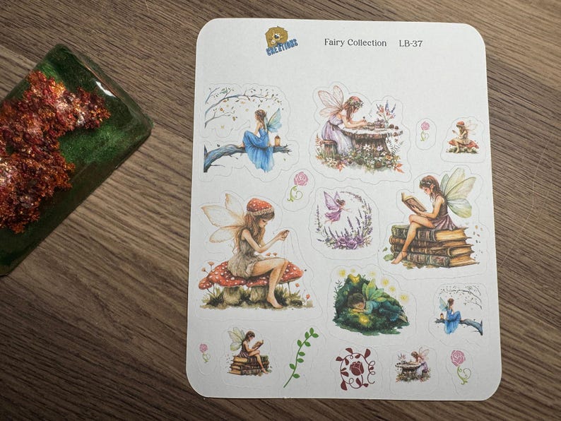 May include: A sheet of fairy-themed stickers. The stickers feature illustrations of fairies in various poses, including reading, writing, and sitting on mushrooms. The stickers are colorful with a whimsical design.