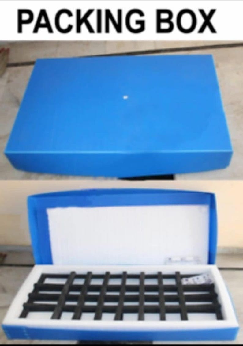 Puede incluir: Una caja de embalaje azul, con el texto "PACKING BOX" en la parte superior. La caja se muestra cerrada y abierta, revelando un interior blanco y una estructura de rejilla negra. La caja est&aacute; dise&ntilde;ada para embalaje y env&iacute;o.