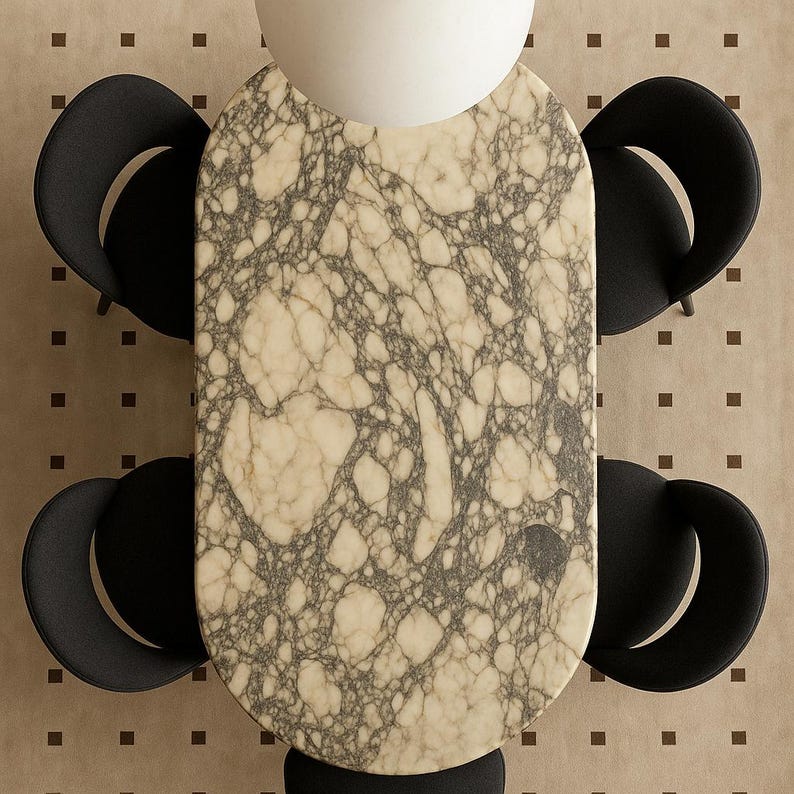 Puede incluir: Vista a&eacute;rea de una mesa de comedor con tapa de m&aacute;rmol y cuatro sillas negras. La mesa tiene un fondo beige claro con vetas gris oscuro. Las sillas son negras con respaldos curvos, dispuestas alrededor de la mesa.